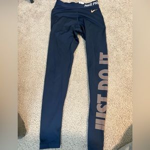 Nike; navy blue leggings with gold Nike writing down the leg; size small